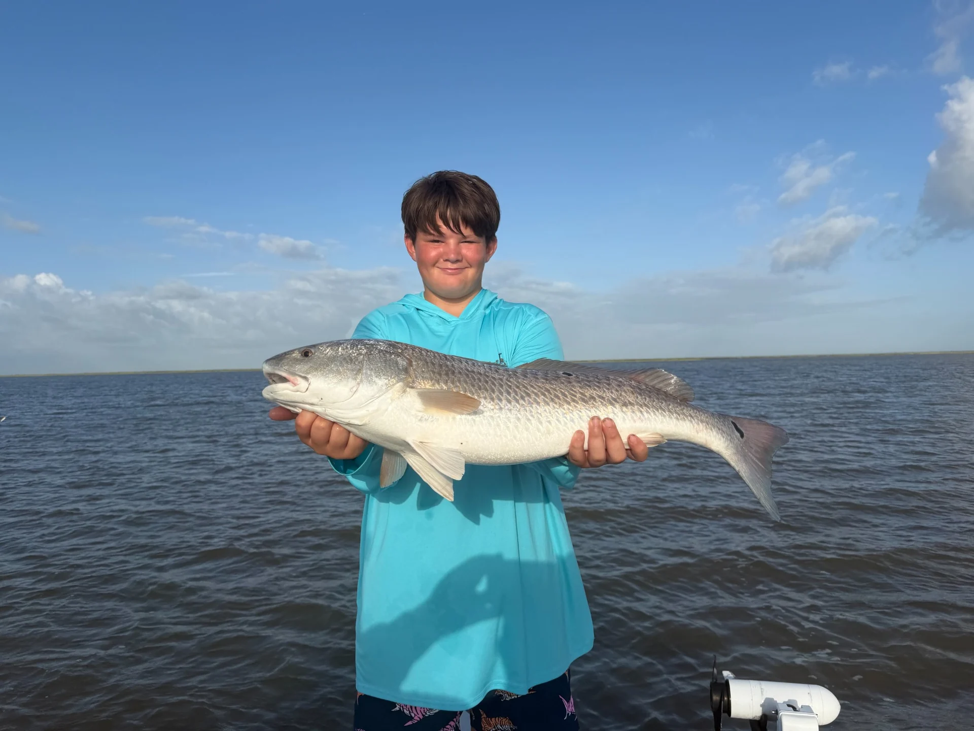Guest holding a redfish caught on the coast